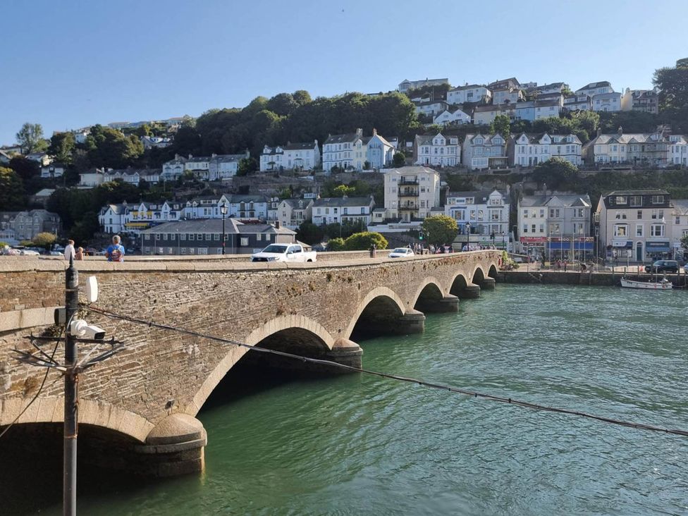 A bridge over the river with buildings and people at Looe Cottage Seaside views log fire sleeps 4 Looe