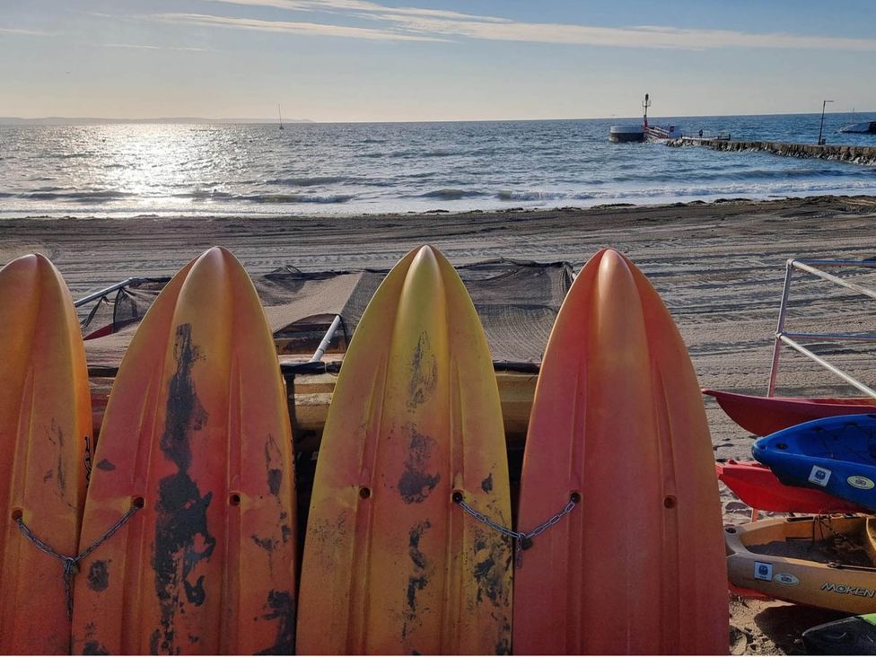 Four surfboards lined up on the beach with ocean in the background at Looe Cottage Seaside views log fire sleeps 4 Looe