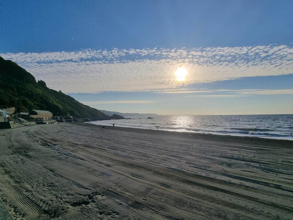 A beach with hills and the ocean at Looe Cottage Seaside views log fire sleeps 4 in Looe
