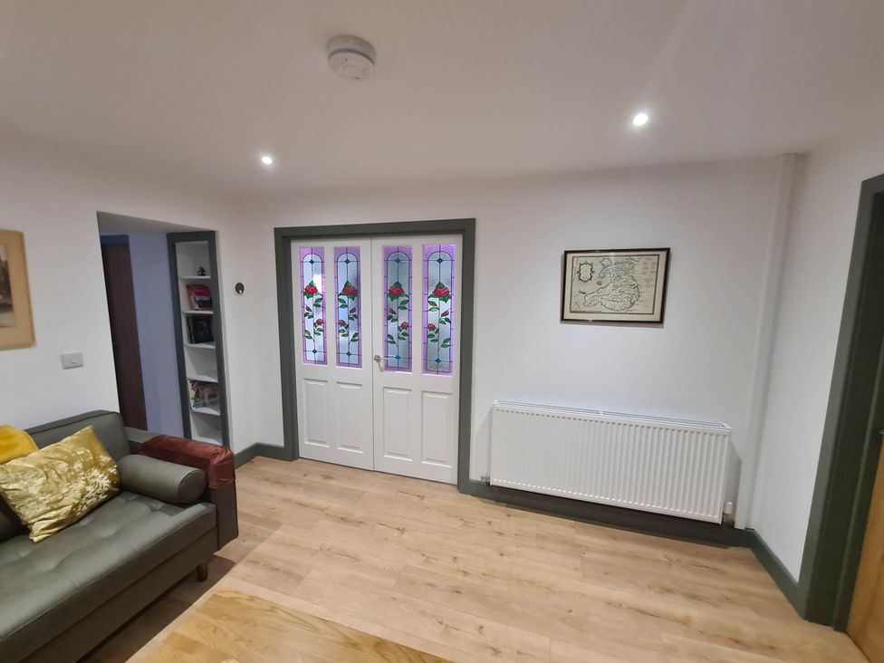 A living room with a sofa and a front door at Conwy Charm Cottage 3 Bed Retreat Penmaenmawr