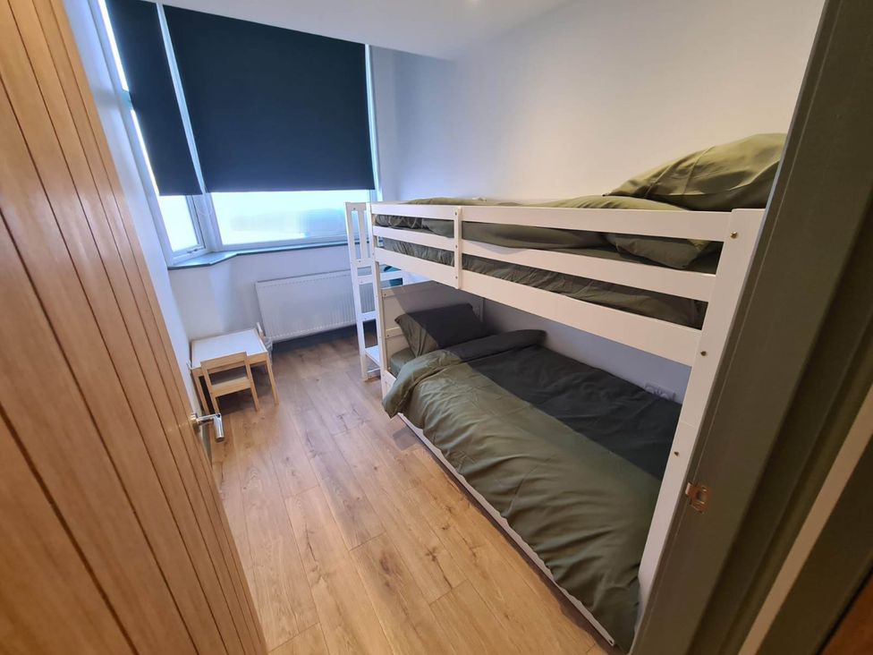A bedroom with a bunk bed and a chair at Conwy Charm Cottage 3 Bed Retreat Penmaenmawr