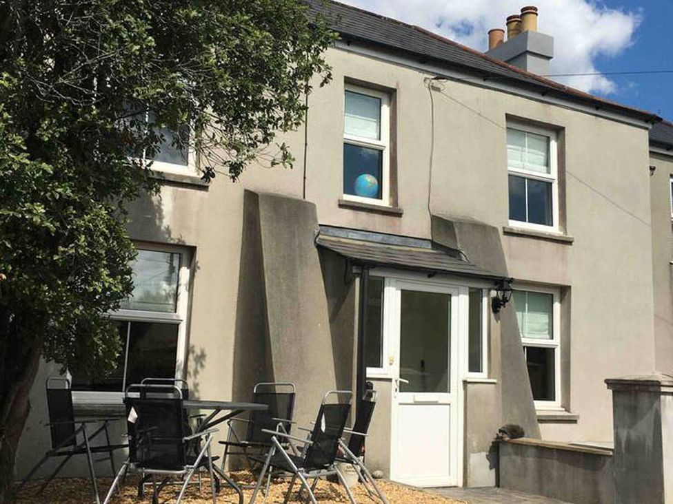 A house with a door and windows with chairs and a table outside at 3Bed Cottage Plymouth Dog friendly Sleeps7, Plymouth