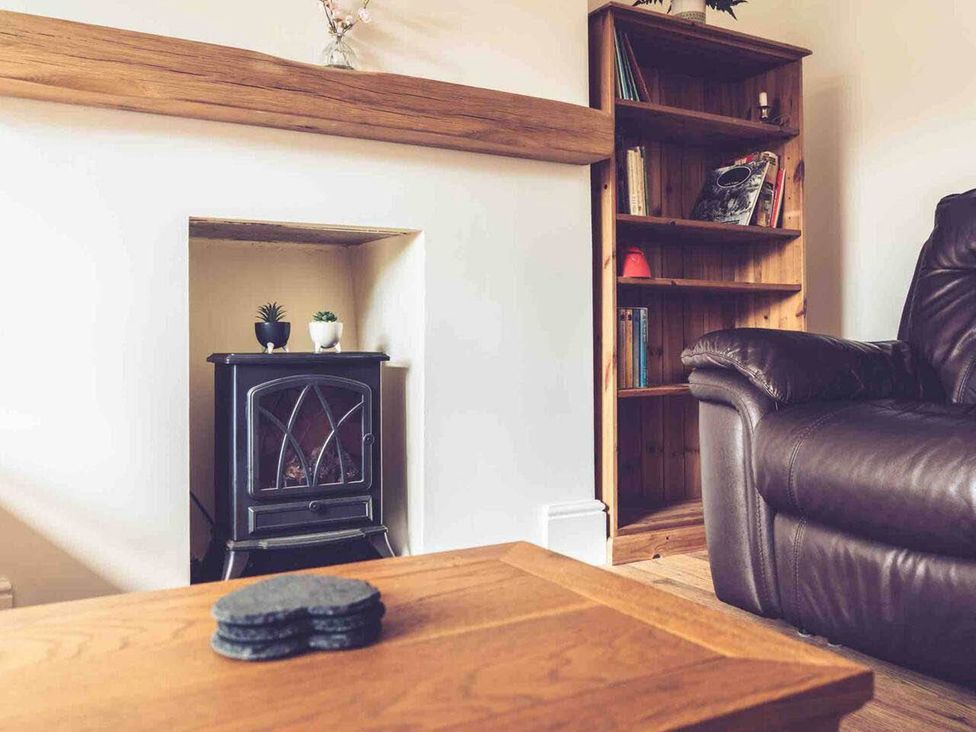 A living room with a fireplace and bookshelf at 3Bed Cottage Plymouth Dog friendly Sleeps7 in Plymouth