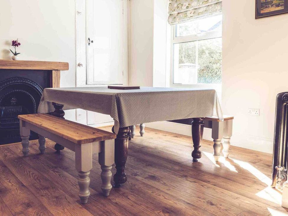 A dining room with a table and benches at 3Bed Cottage Plymouth Dog friendly Sleeps7 in Plymouth