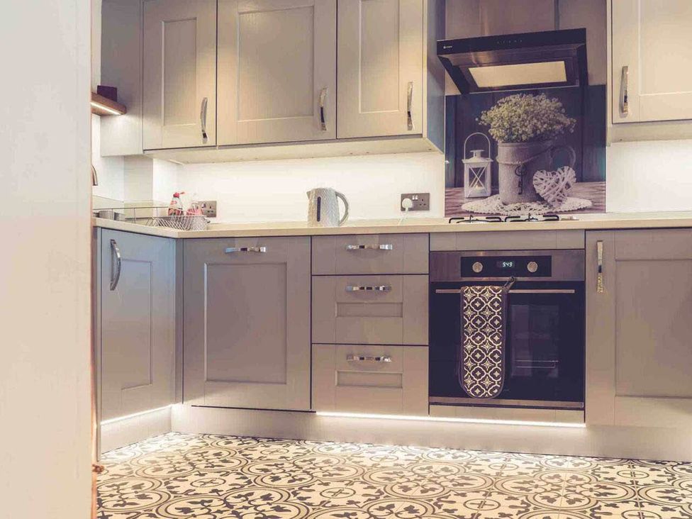 A kitchen with cabinets, an oven, a kettle, and a sink at 3Bed Cottage Plymouth Dog friendly Sleeps7 in Plymouth