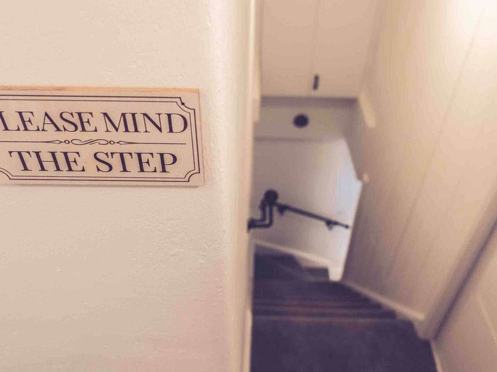 A staircase with a sign saying please mind the step at 3Bed Cottage Plymouth Dog friendly Sleeps7 Plymouth