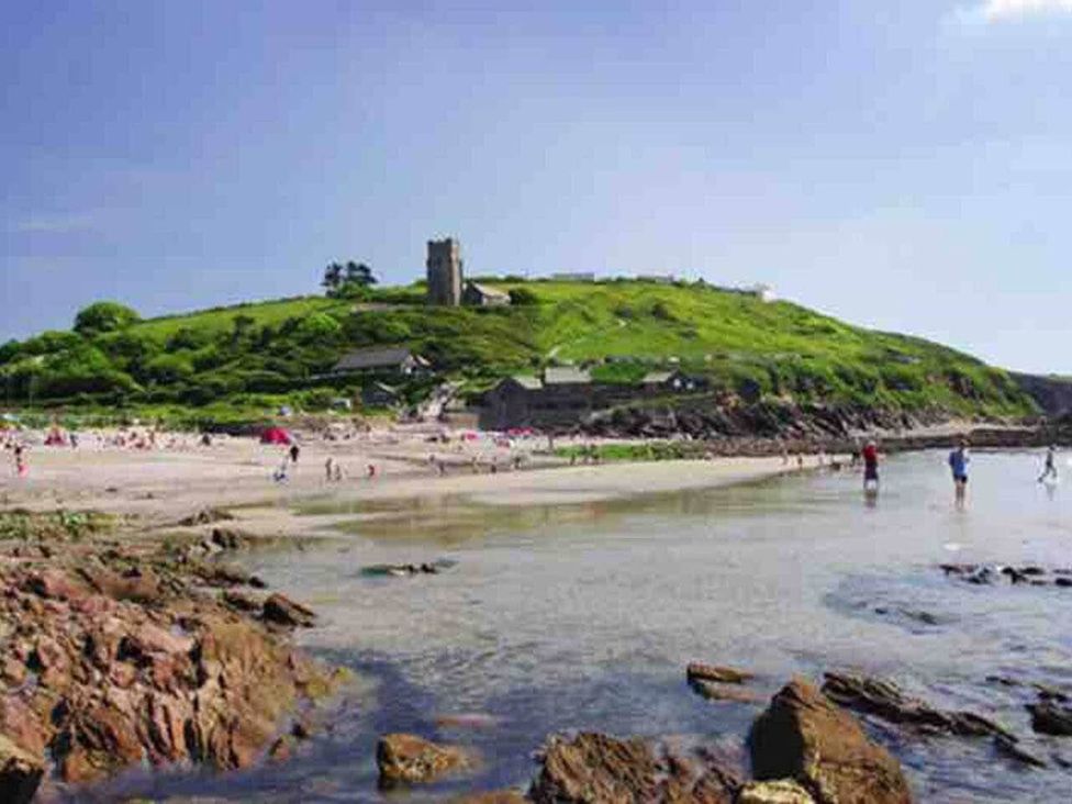A beach area with people walking and a hill with a church at 3Bed Cottage Plymouth Dog friendly Sleeps7 Plymouth