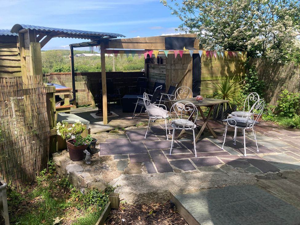 An outdoor seating area with a table and chairs at The Owl House in countryside setting near Niwbwrch (newborough)