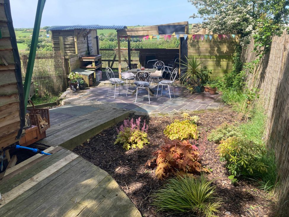 A garden with a patio area and seating at The Owl House in countryside setting near Niwbwrch (newborough)