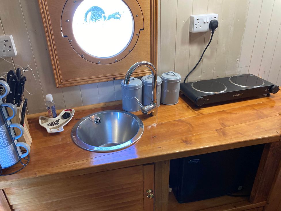 A kitchen with a sink and electric stove at The Owl House in countryside setting near Niwbwrch (newborough)