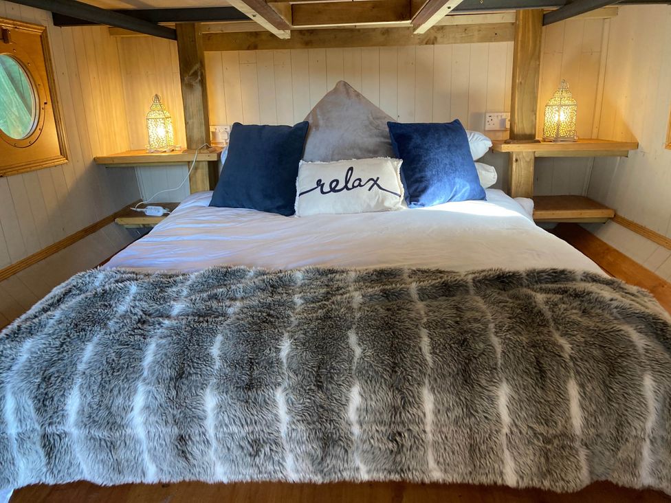 A bedroom with a bed and pillows at The Owl House in countryside setting near Niwbwrch (newborough)