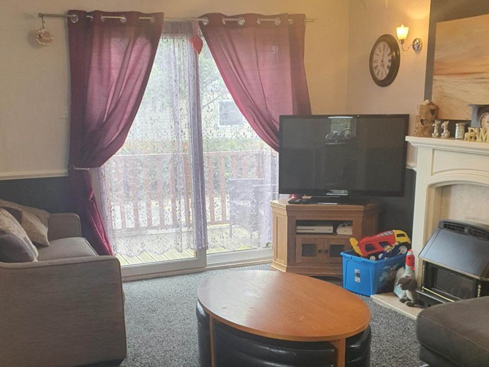 A living room with a television and sofa at The Old Barn in Fleetwood