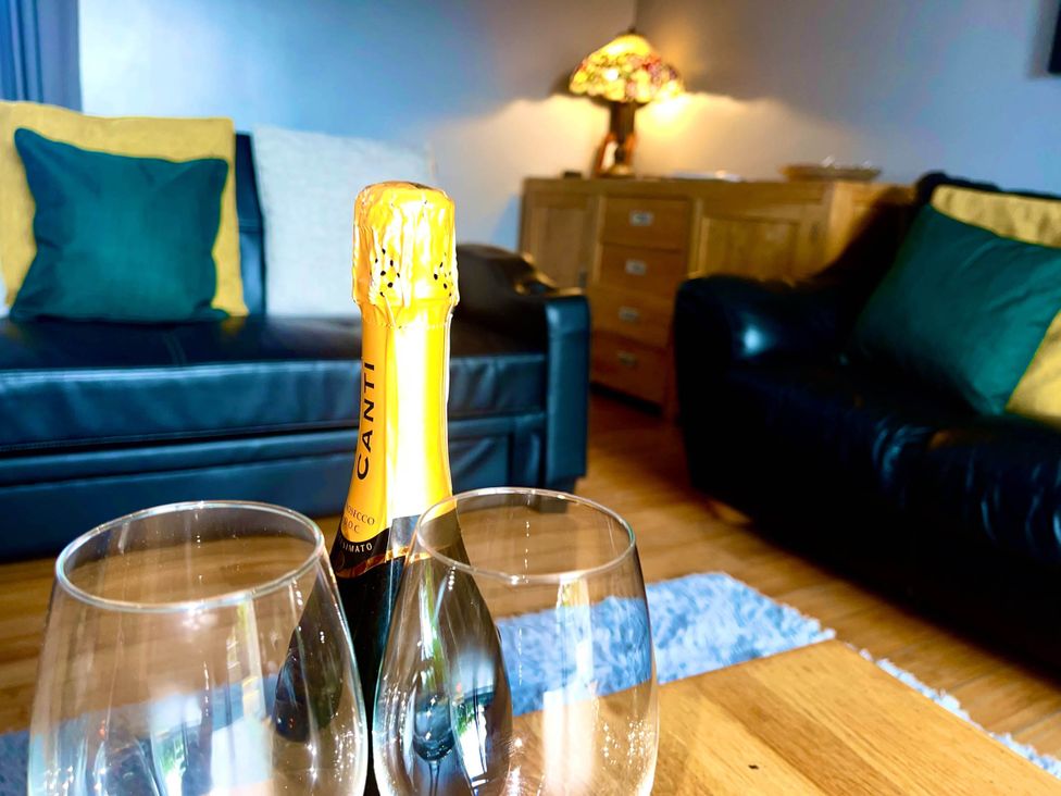 A living room with a champagne bottle and glasses at The Old Barn in Tanygrisiau near Blaenau Ffestiniog