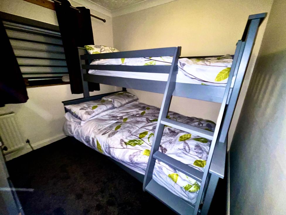 A bedroom with a bunk bed and bedding at Tanygrisiau near Blaenau Ffestiniog