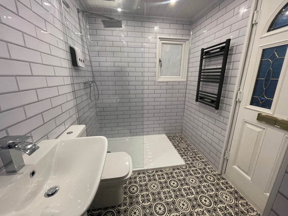 A bathroom with a shower, toilet, and sink at The Old Barn in Tanygrisiau near Blaenau Ffestiniog