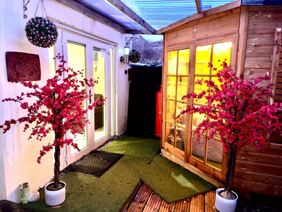 A garden area with artificial trees and a wooden garden house at Tanygrisiau near Blaenau Ffestiniog