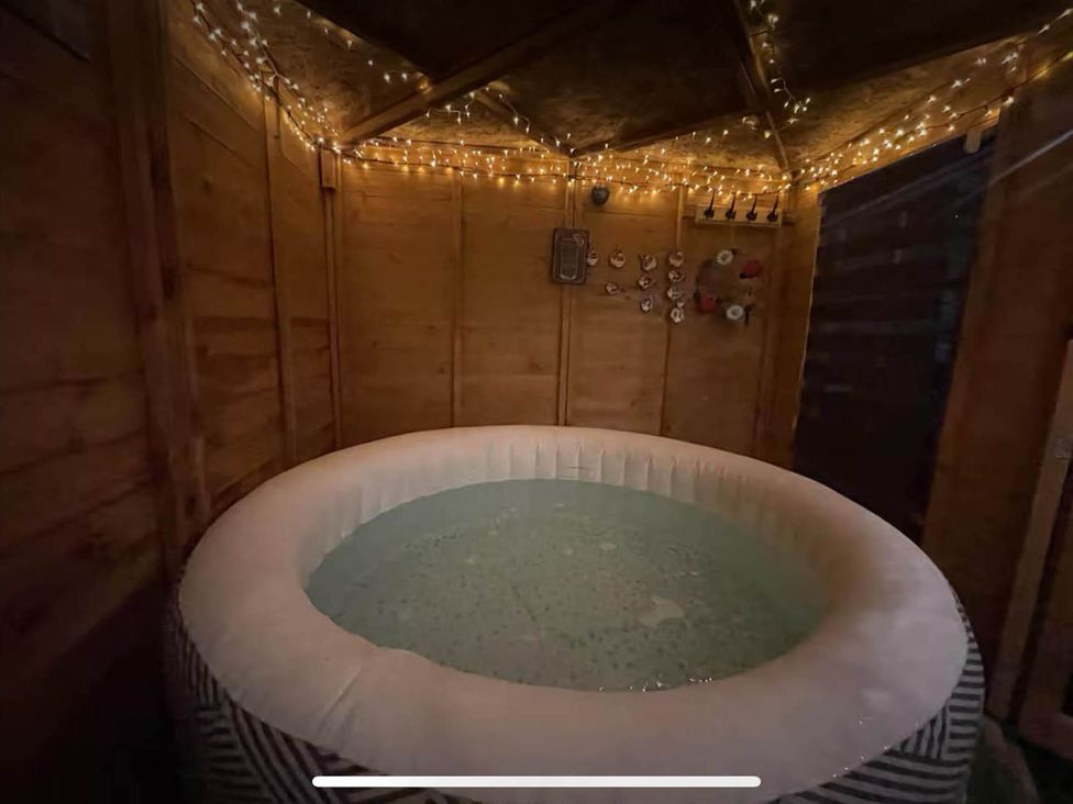 A hot tub in a wooden structure with lights at Tanygrisiau near Blaenau Ffestiniog