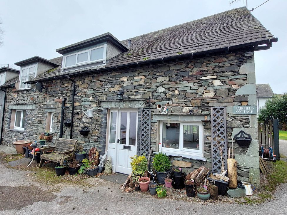 A stone cottage with plants outside at Fairfield Cottage in Hawkshead