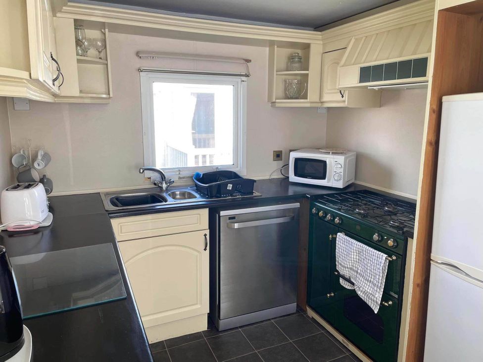A kitchen with a sink, microwave, oven, and dishwasher at The Old Barn in Manchester
