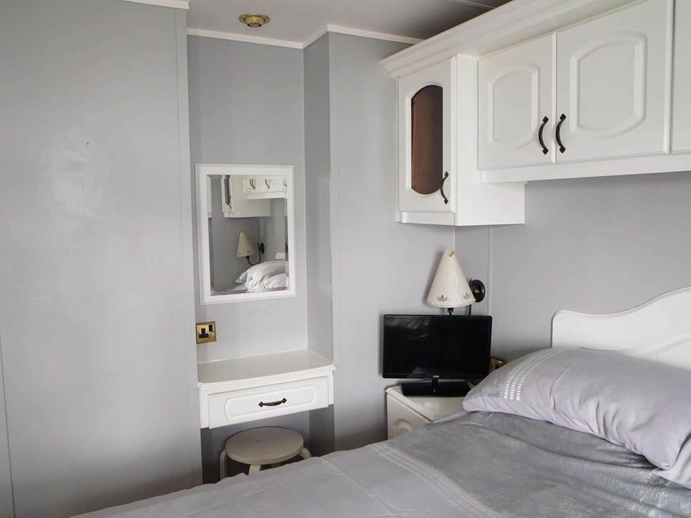 A bedroom with a bed, nightstand, lamp, and a television at the property in the location