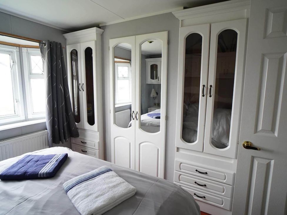 A bedroom with a bed and wardrobes at The Old Barn in Manchester