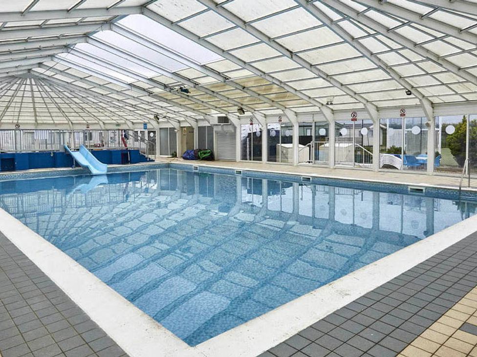 An indoor swimming pool with a slide at a leisure facility in an unspecified location