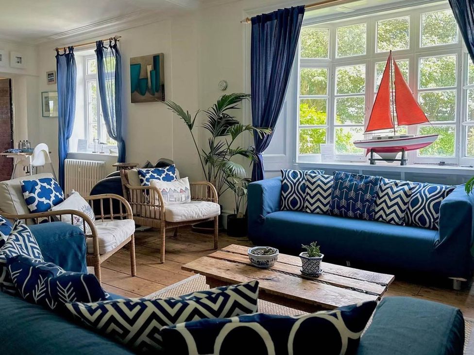 A living room with furniture and a decorative sailboat at Norfolk Seaview Luxury Retreat with 7 Bedrooms in Mundesley