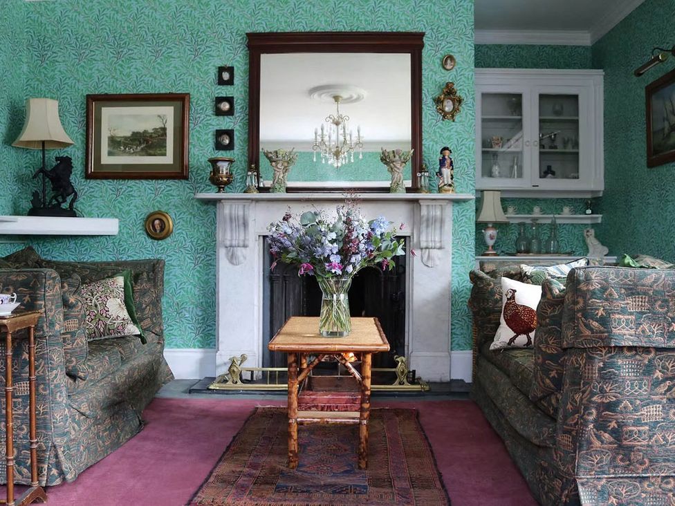 A living room with a table and floral arrangement at Norfolk Seaview Luxury Retreat with 7 Bedrooms in Mundesley