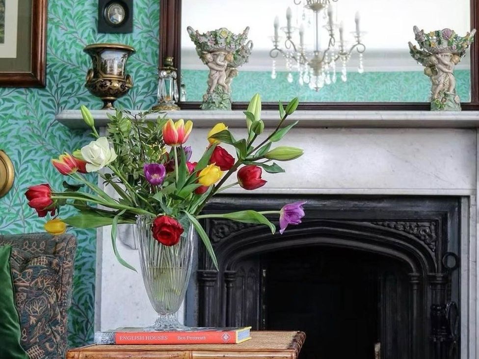 A living room with a vase of flowers on a table at Norfolk Seaview Luxury Retreat with 7 Bedrooms Mundesley