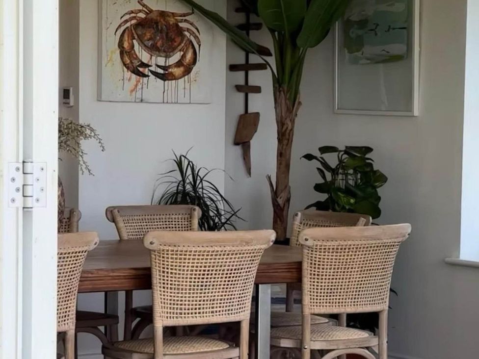 A dining room with a wooden table and chairs at Norfolk Seaview Luxury Retreat with 7 Bedrooms in Mundesley
