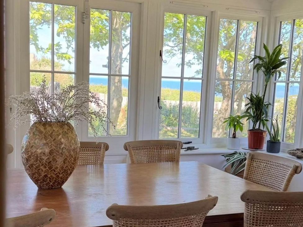 A dining room with a table and chairs at Norfolk Seaview Luxury Retreat with 7 Bedrooms Mundesley
