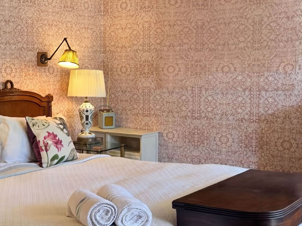 A bedroom with a bed and bedside table at Norfolk Seaview Luxury Retreat with 7 Bedrooms Mundesley