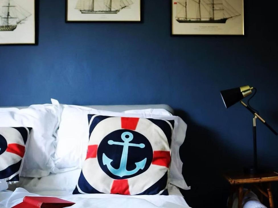 A bedroom with bed and nautical themed pillows at Norfolk Seaview Luxury Retreat with 7 Bedrooms in Mundesley