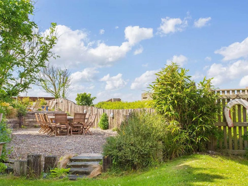 A garden with a table and chairs at Norfolk Seaview Luxury Retreat with 7 Bedrooms Mundesley