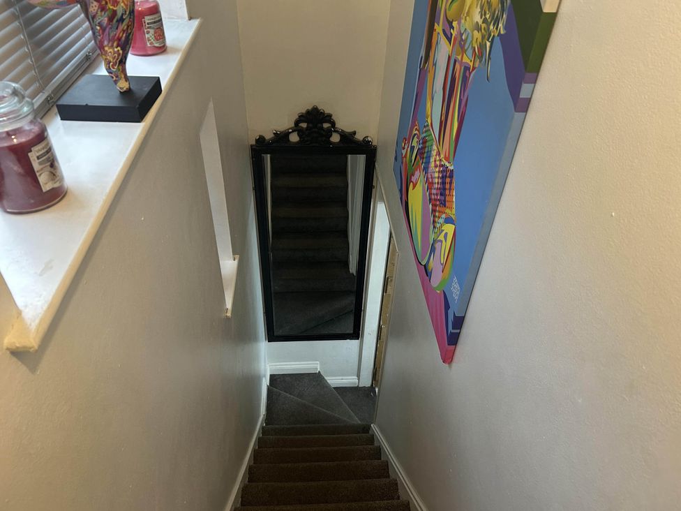 A staircase with a mirror and wall art at Immaculate 3Bed House in Bridgnorth