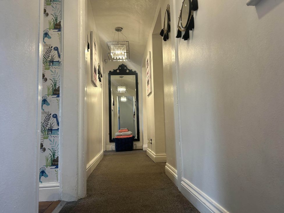 A hallway with a mirror and decorative wall art at Immaculate 3Bed House in Bridgnorth