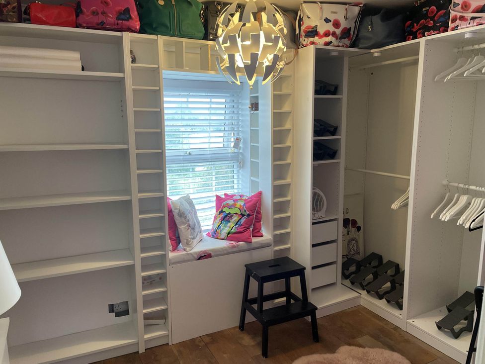 A dressing room with shelves, a window, and a stool at Immaculate 3Bed House in Bridgnorth