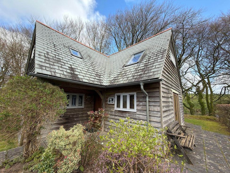 A wooden house with a sloped roof and garden at Tremail near Camelford