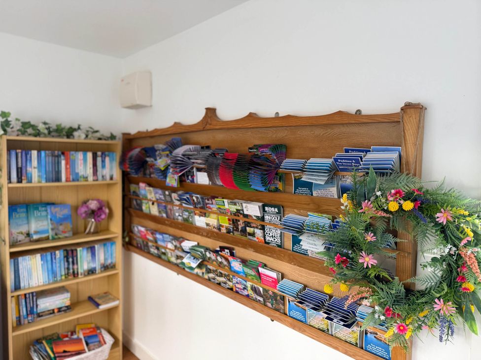 A brochure display and bookshelf at a property in Tremail near Camelford