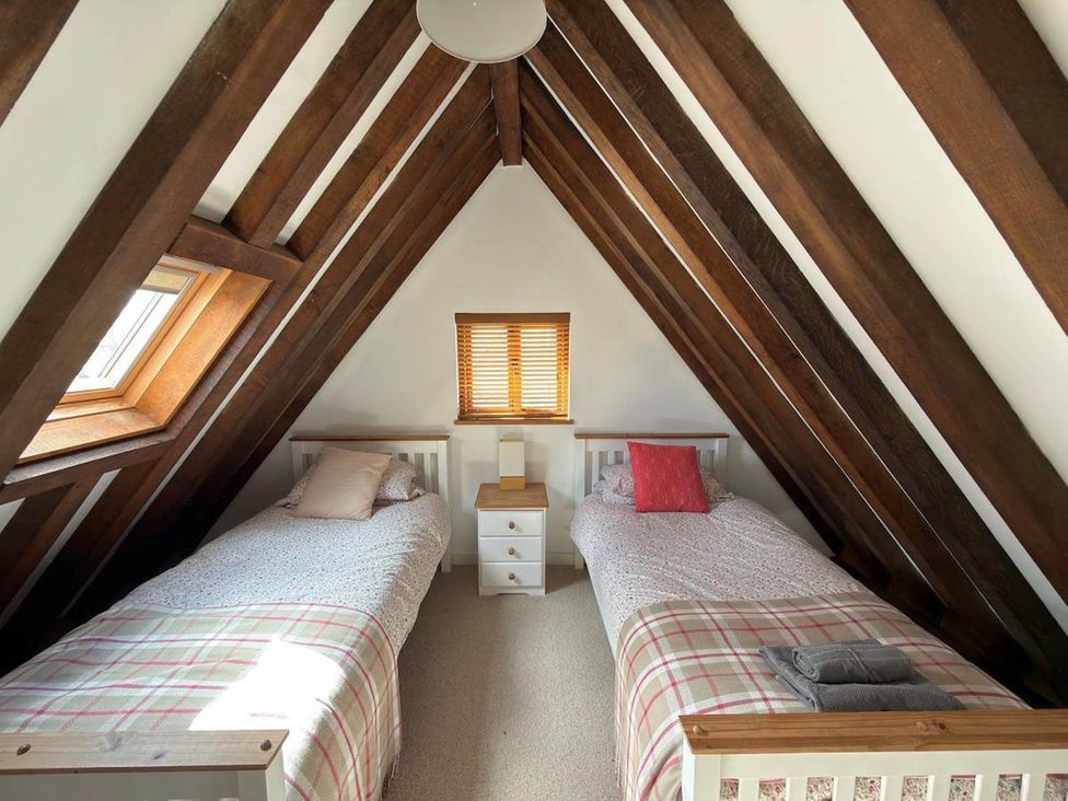 A bedroom with two single beds and wooden beams at Tremail near Camelford