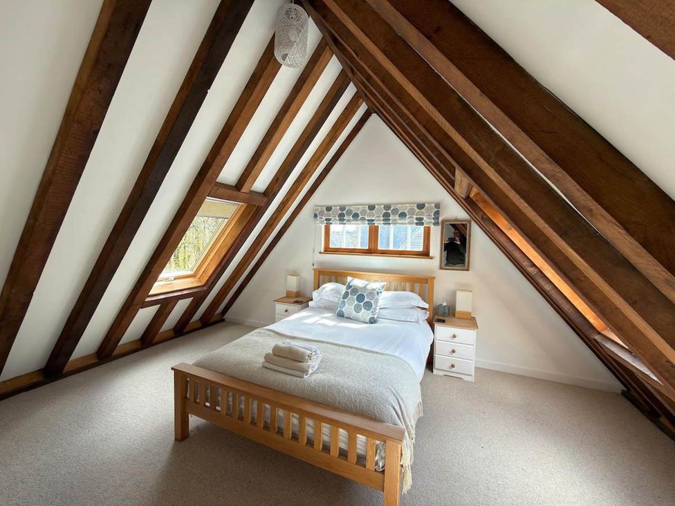 A bedroom with a bed and two nightstands at Tremail near Camelford