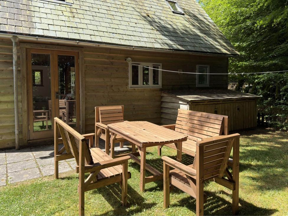 A wooden table and chairs in an outdoor area at Tremail near Camelford