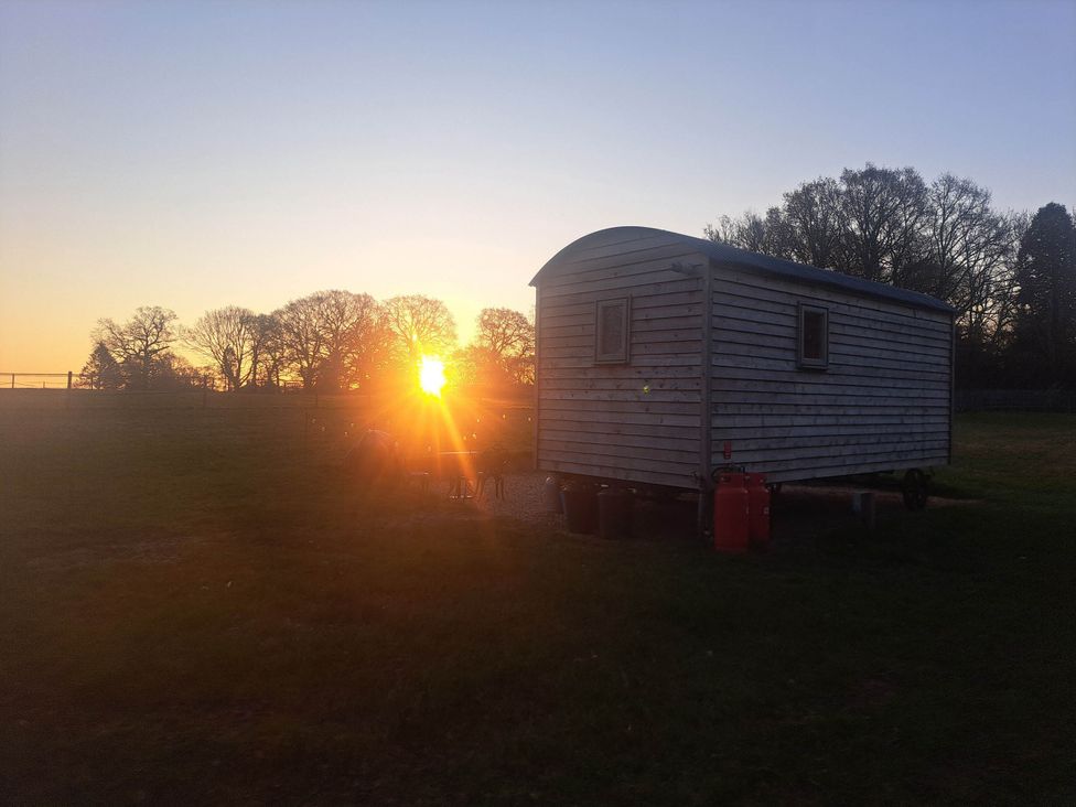 A hut with gas canisters and sunset in a field near Bishop's Waltham