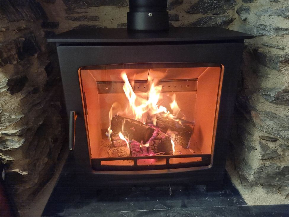 A fireplace with firewood and flames at a property near Bishop's Waltham