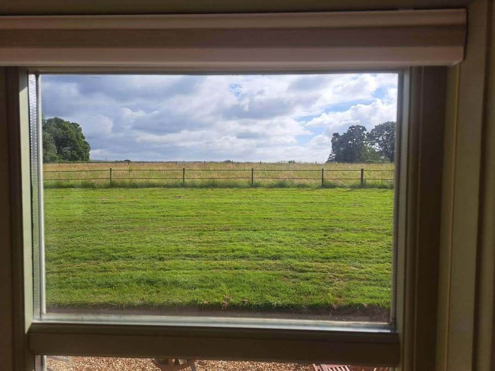 A view through a window overlooking a grassy field at 