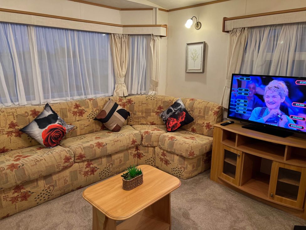 A living room with a sofa and a television at a property near West Mersea
