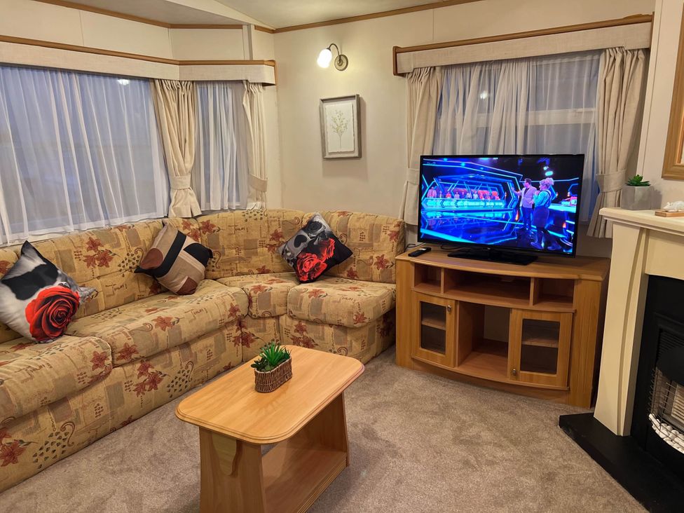 A living room with a sofa and a television at the property Near West Mersea