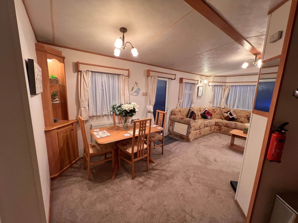 A living room with a table and chairs at a property near West Mersea