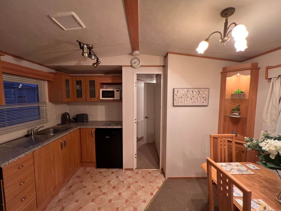 A kitchen with wooden cabinets and a dining area at 