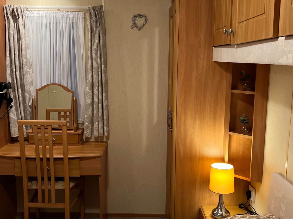 A bedroom with a dressing table and lamp at 
